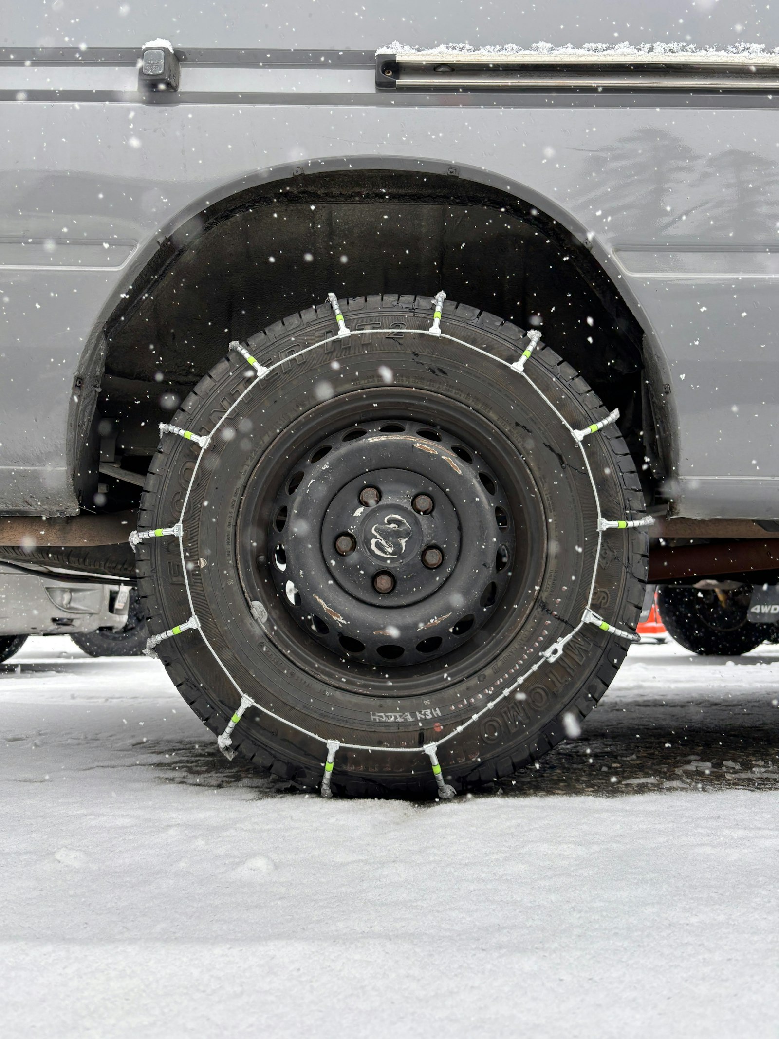Tire chains fitted on a car wheel in snow