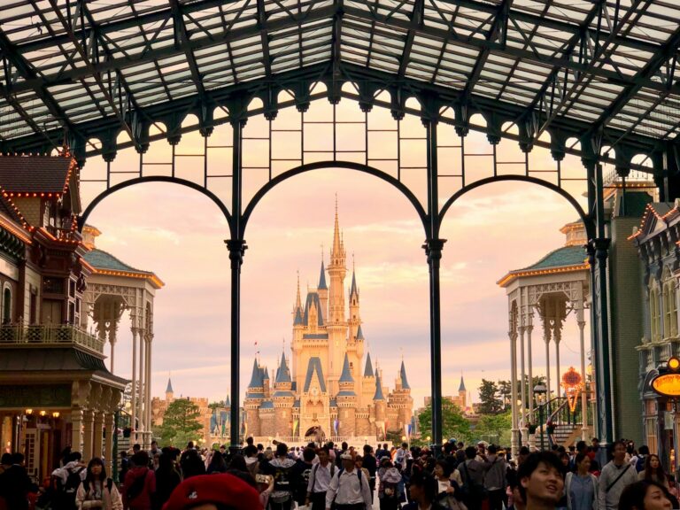 Cinderella Castle seen through the glass arches of World Bazaar at Tokyo Disneyland at sunset