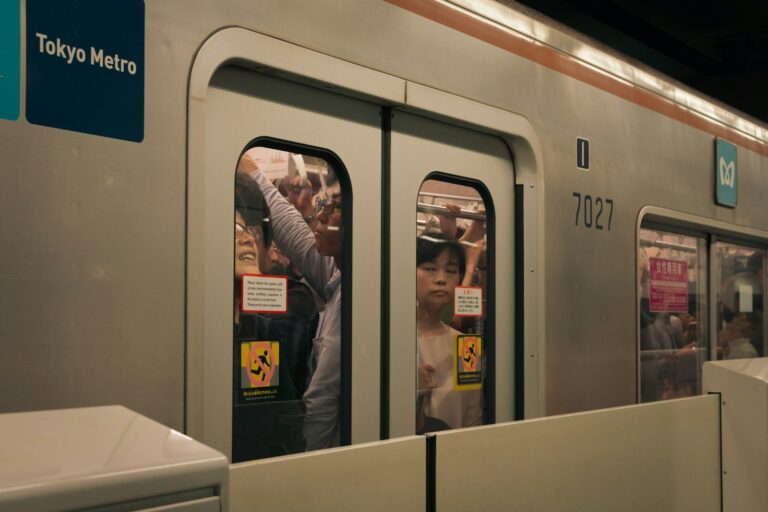 Silver Tokyo Metro train with its doors open at a subway platform