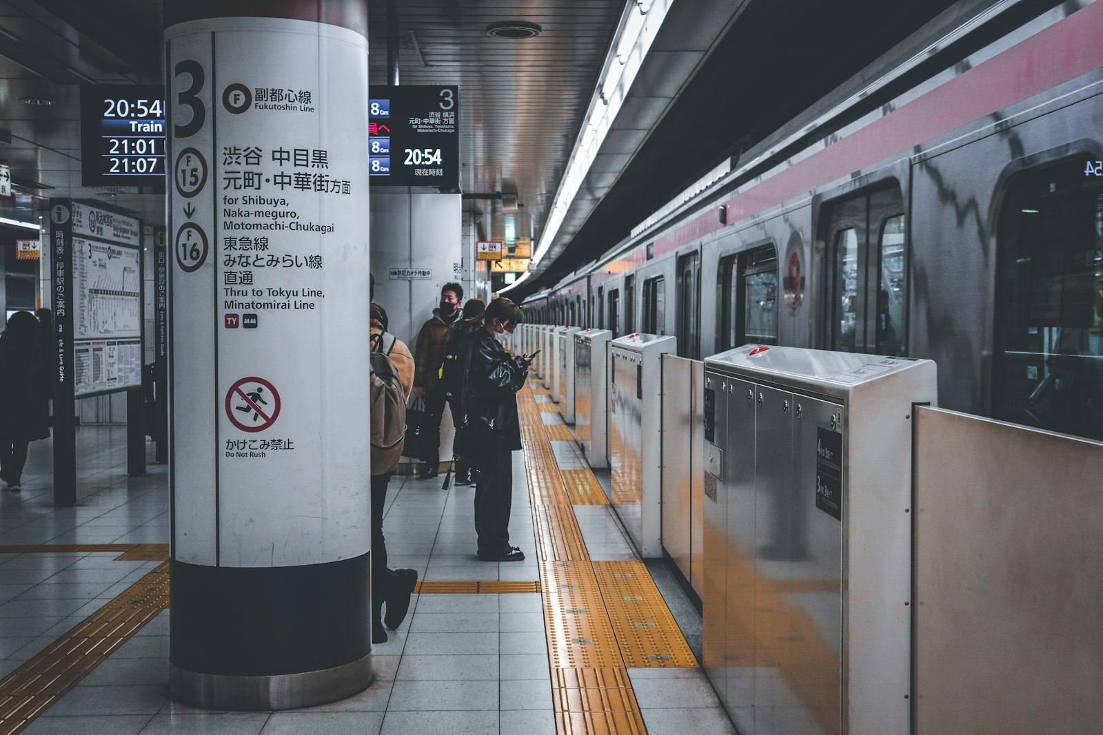 Tokyo subway platform with screen doors and a train