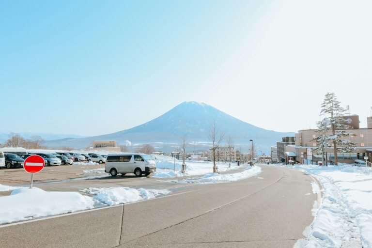 Snow-lined road with cars and Mount Yotei in Hokkaido in winter