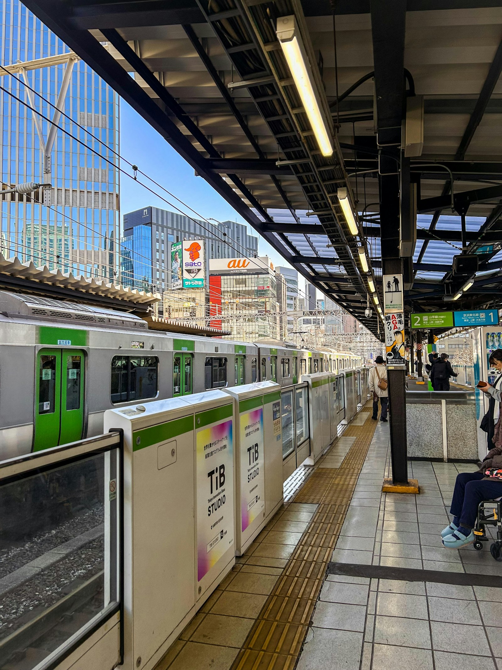 Green-striped Yamanote Line train at a platform in Tokyo