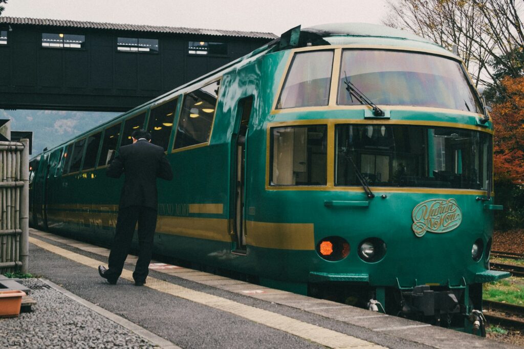 The green Yufuin no Mori limited express train at a station platform